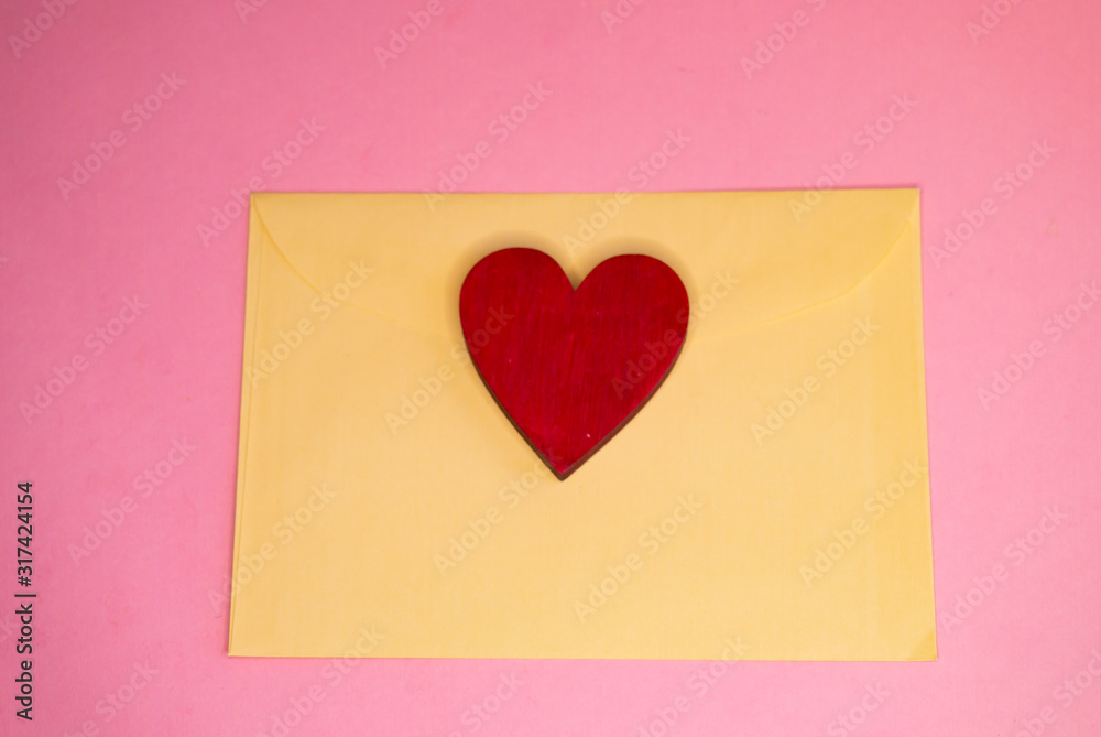 red heart on a pink background on a yellow envelope