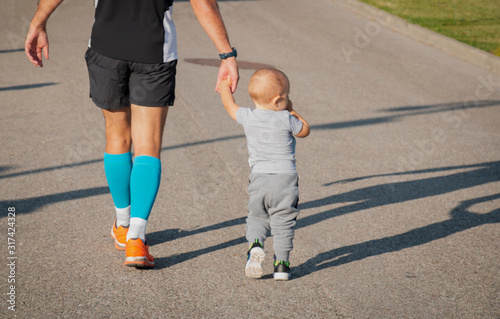 dad holds the hand of the baby son helped to overcome the distance, father support