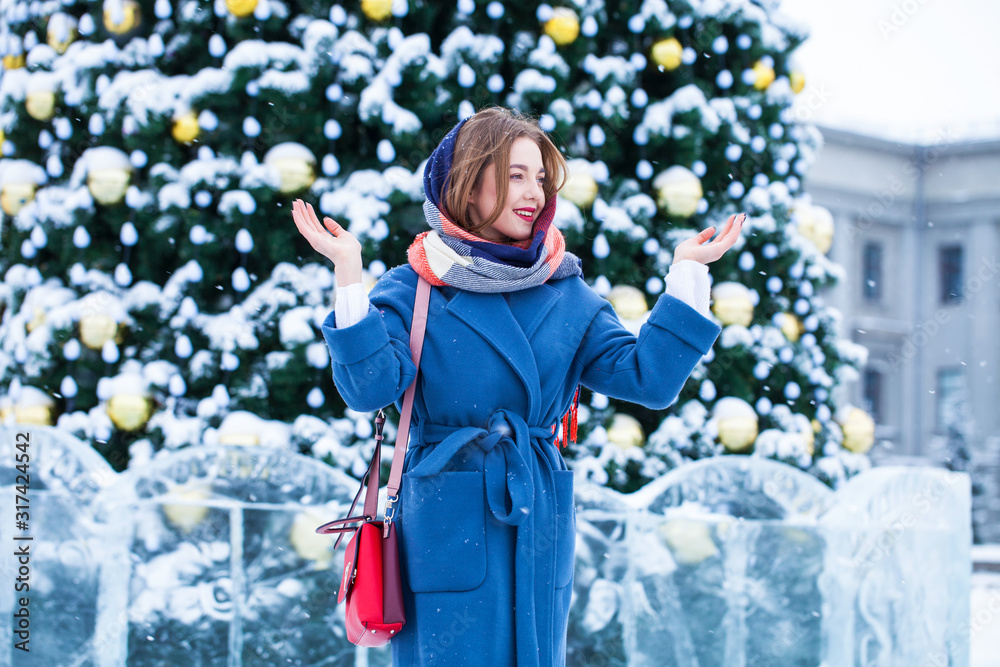 Happy young girl in blue coat posing in winter street Happy young girl in blue coat posing in winter street