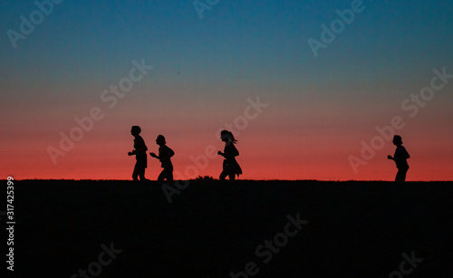 two girls running around the city marathon at sunset