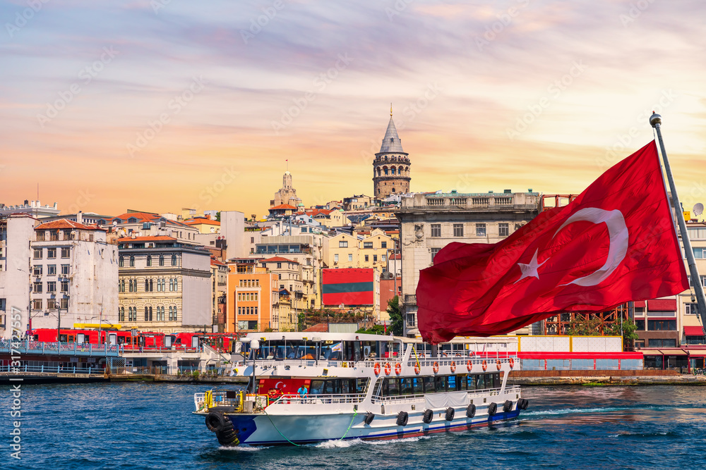 Karakoy pier, a ferry, Turkish flag and the Galata Tower in the background, Istanbul, Turkey