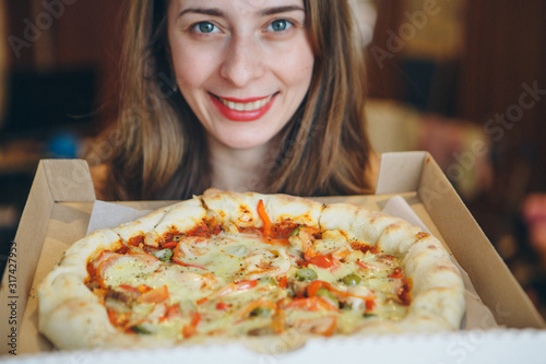 Portrait of a happy girl with a pizza in her hands. fast food advertising, confectionery, cooking, overeating, diet, Italian food