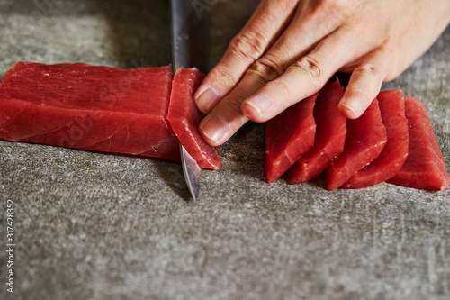 Slicing tuna saku block with sashimi knife
