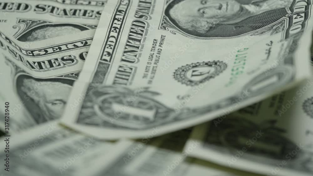 dented one dollar banknotes lie on large money pile and rotate leaving dark shadows extreme close view dented one dollar banknotes lie on large money pile and rotate leaving dark shadows extreme close view