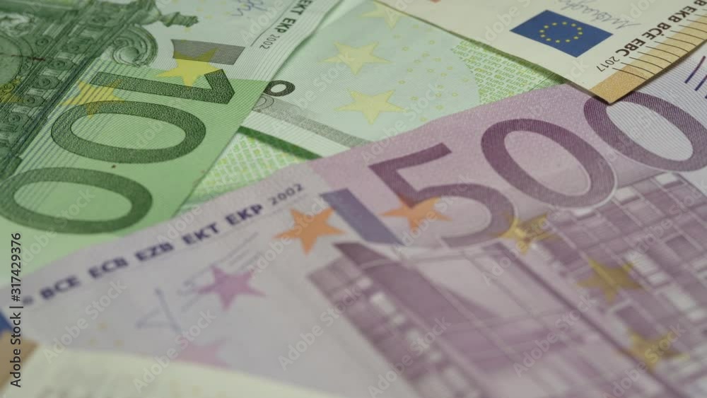 coloured euro banknotes of different face value lie on money pile and rotate under electric light extreme close view coloured euro banknotes of different face value lie on money pile and rotate under electric light extreme close view