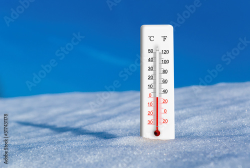 Fényképezés White thermometer in snow against blue sky