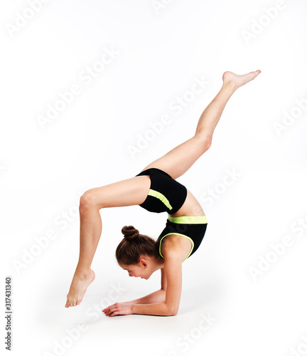 Flexible cute little girl child gymnast doing acrobatic exercise isolated on a white background
