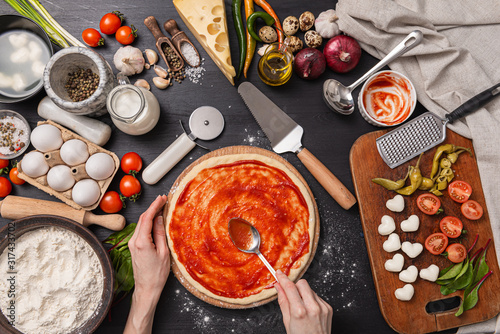 Classic pizza margherita with heart-shaped mazarella cheese. preparing a phased gala dinner for two at home in honor of Valentine's Day. photo