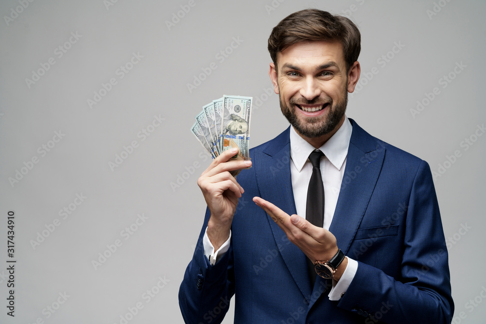 young handsome businessman holding US dollar bills young handsome businessman holding US dollar bills