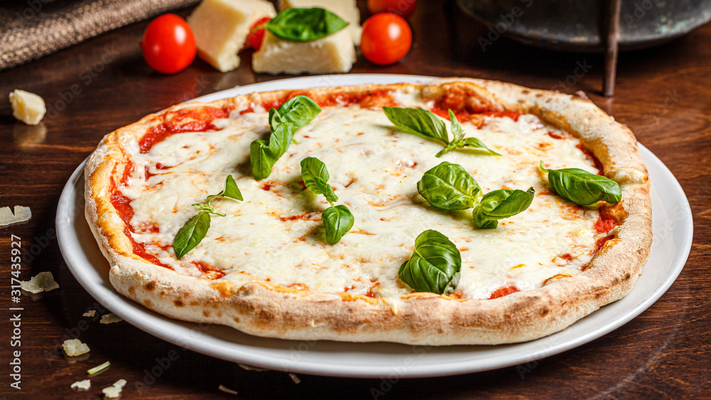 talian Cuisine. Classic Italian pizza Margherita with basil, cheese and tomatoes. Serving dishes in a restaurant on a white plate. background image, copy space text