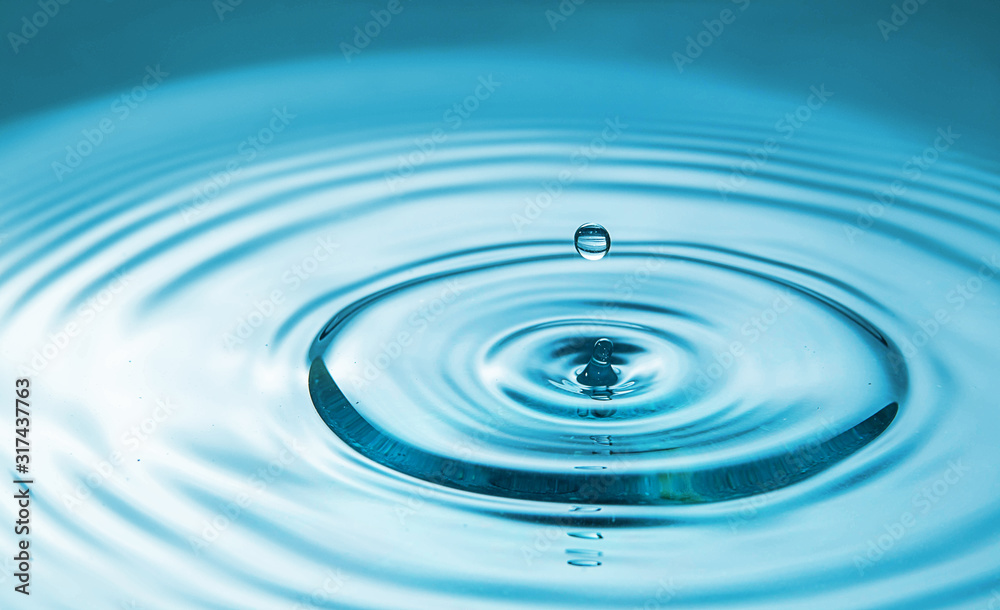 Closeup Water drop falling on the surface of the water and beautiful circular wave ripple, fresh natural mineral water drink water concept Closeup Water drop falling on the surface of the water and beautiful circular wave ripple, fresh natural mineral water drink water concept