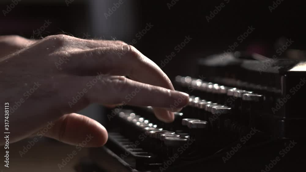 writer types on typewriter keyboard