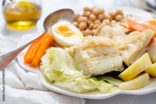 boiled fish with vegetables and boiled egg on white plate