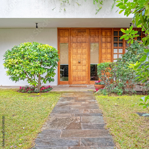 contemporary house garden with stone path to the wooden entrance door, Athens Greece