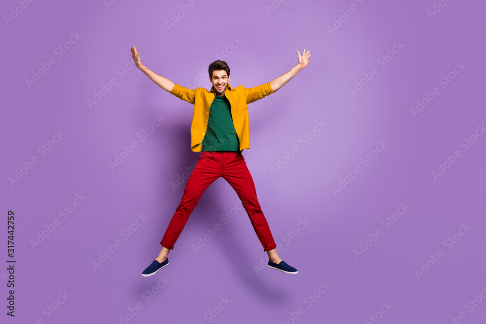Full length photo of positive cheerful guy jump raise hands like start enjoy spring holidays wear causal style clothing isolated over vivid color background
