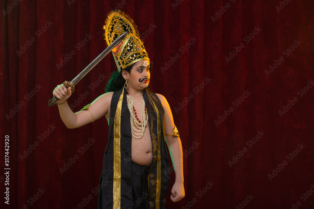 child dressed up as ravan standing on stage with a sword Stock Photo ...