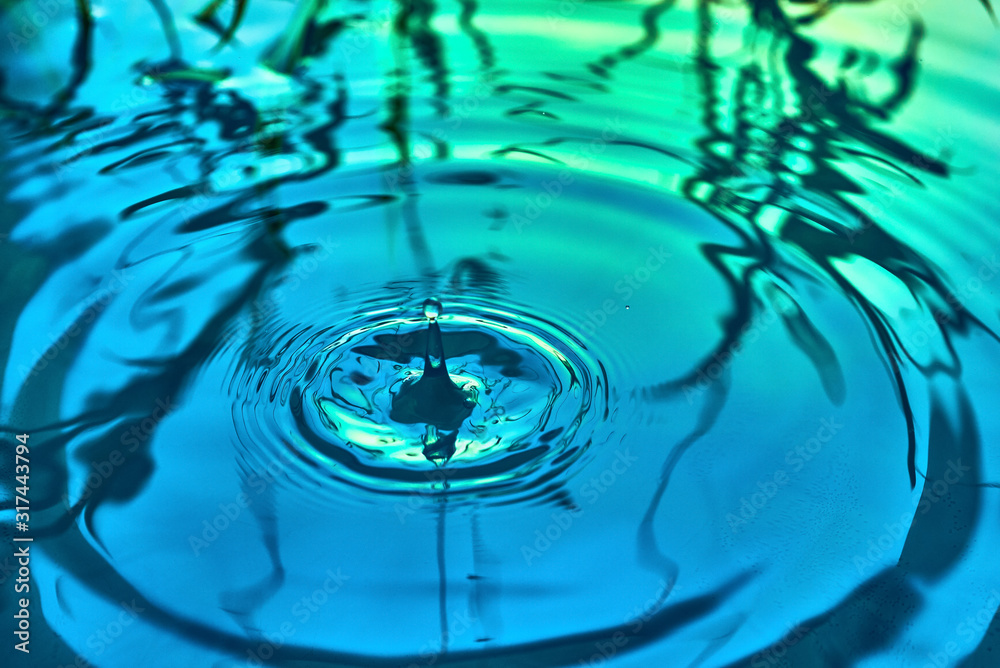 Raindrops fall on the surface of the water. The circles from the raindrops on the water surface. Abstract color background of circles on the water and falling drops. Raindrops fall on the surface of the water. The circles from the raindrops on the water surface. Abstract color background of circles on the water and falling drops.