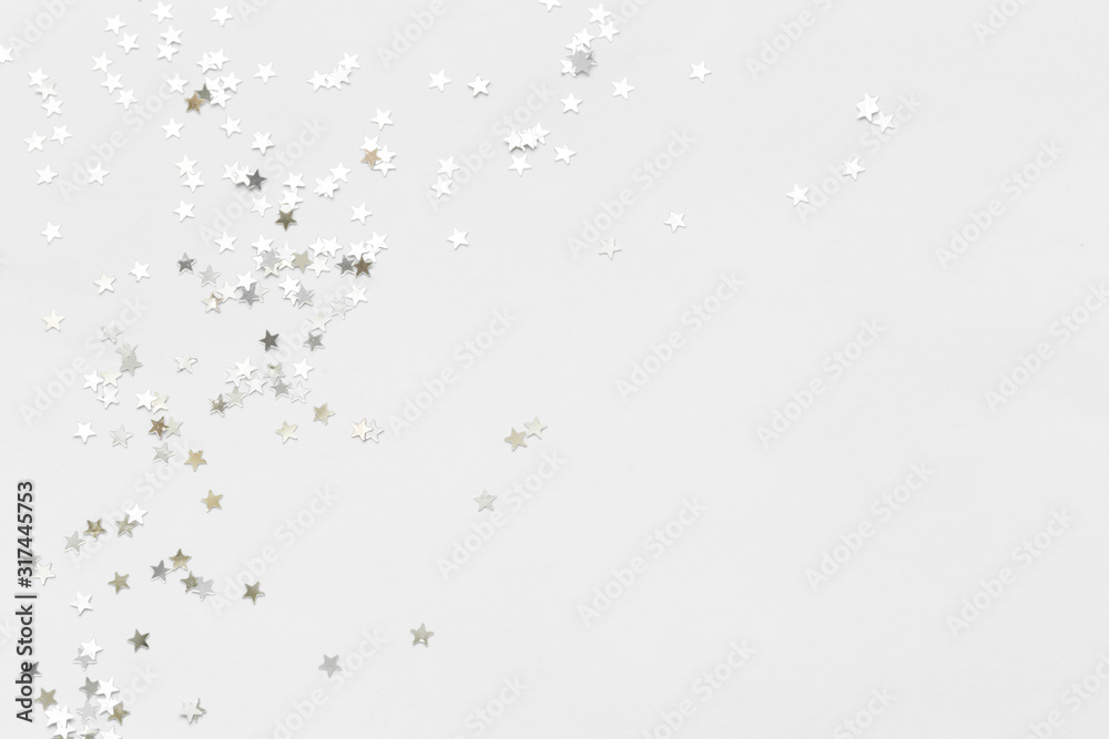 Silver confetti and stars and sparkles on a light background. Top view, flat lay. Copy text. holiday background. For Christmas, New Year, Valentine's Day Silver confetti and stars and sparkles on a light background. Top view, flat lay. Copy text. holiday background. For Christmas, New Year, Valentine's Day