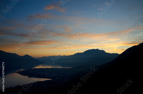 Dusk over an Alpine Lake Maggiore with Orange Clouds in Ticino, Switzerland.