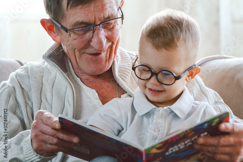 Valokuva Grandfather and grandson are reading a book