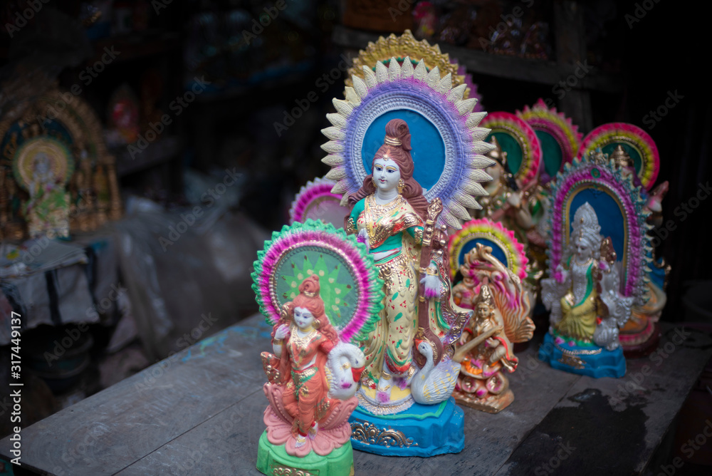Fototapeta premium Clay idols of Hindu Goddess Saraswati being made and displayed for the Indian Bengali festival in winter in Bengal. Indian culture and religion.