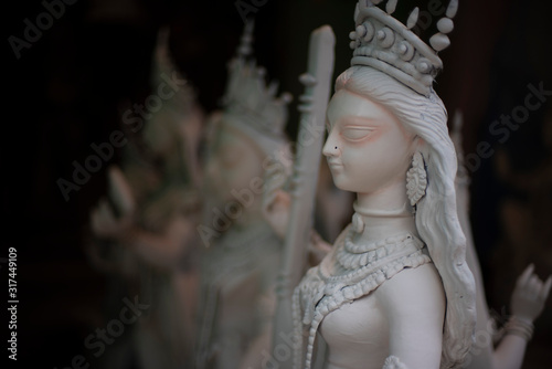 Clay idols of Hindu Goddess Saraswati being made and displayed for the Indian Bengali festival in winter in Bengal. Indian culture and religion. photo