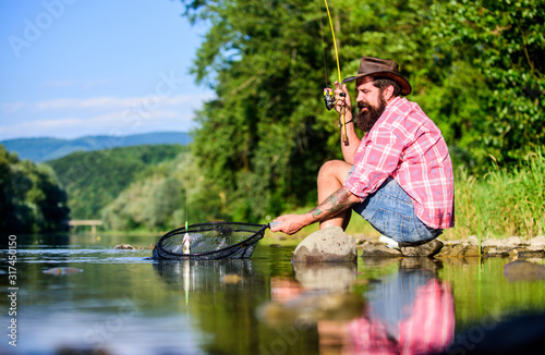 Man catching fish. Guy fly fishing. Successful fly fishing. Hobby for soul. United with nature. Fisherman fishing technique use rod. Man at riverside enjoy peaceful idyllic landscape while fishing