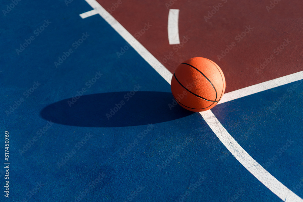 Obraz premium An orange ball on basketball court