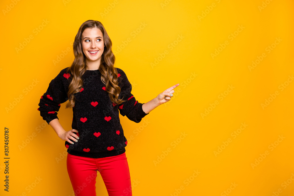 It's sale o'clock. Photo of funny lady indicating finger empty space advising amazing low shopping prices wear hearts pattern pullover red pants isolated yellow color background It's sale o'clock. Photo of funny lady indicating finger empty space advising amazing low shopping prices wear hearts pattern pullover red pants isolated yellow color background