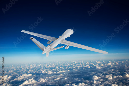 military RC military drone flies flies against backdrop of beautiful ominous clouds on blue sky background. Elements of this image furnished by NASA
