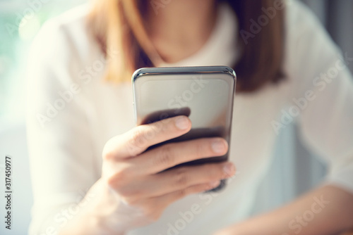 Happy female using smartphone at modern coffee shop, she chatting Online Messaging and social network on mobile. © oatawa