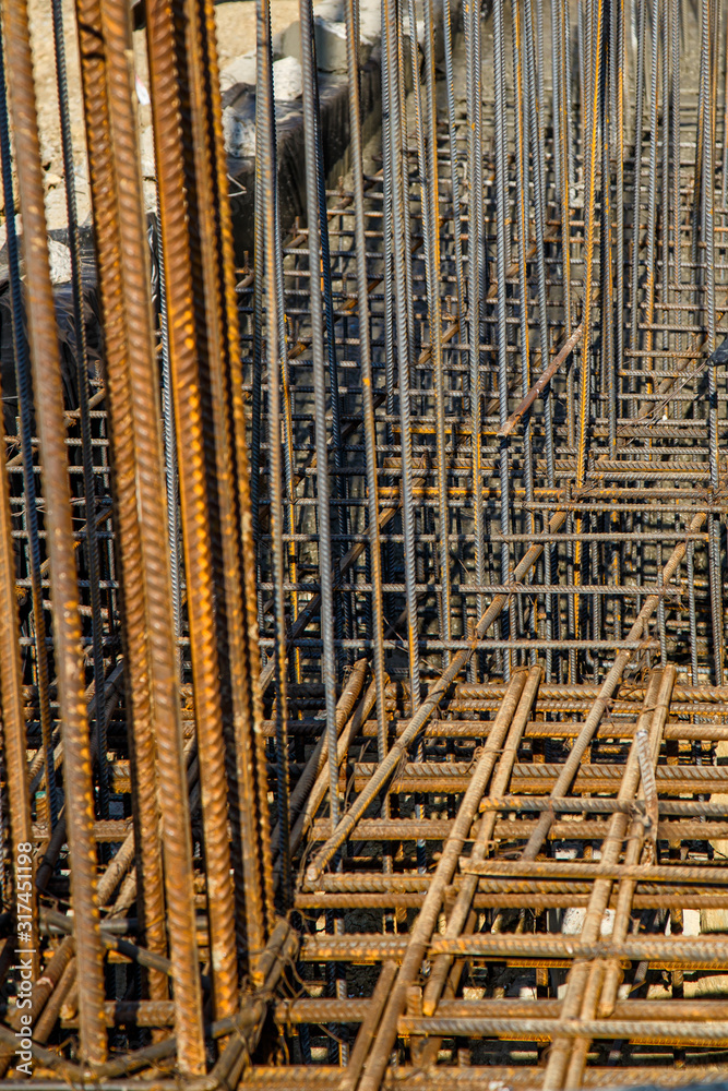 steel rebar for reinforcement concrete at construction site with house under construction background,Industrial background.Rusty rebar for concrete pouring.