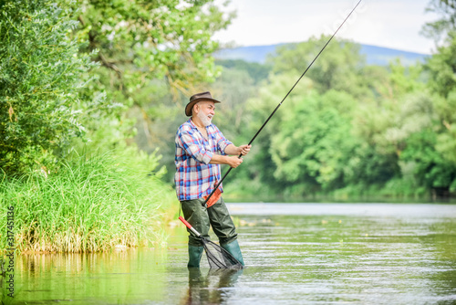 Mature man fishing. Male leisure. Fisherman with fishing rod. Happiness is rod in your hand. Retired fisherman. Senior man catching fish. Activity and hobby. Fishing freshwater lake pond river