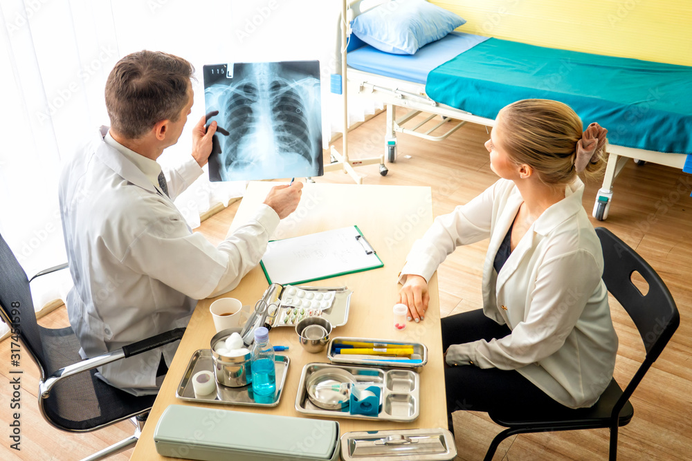 Obraz premium Doctor explaining lungs x-ray to women patient in clinic or Doctor in the office examining an x-ray and discussing with a patient