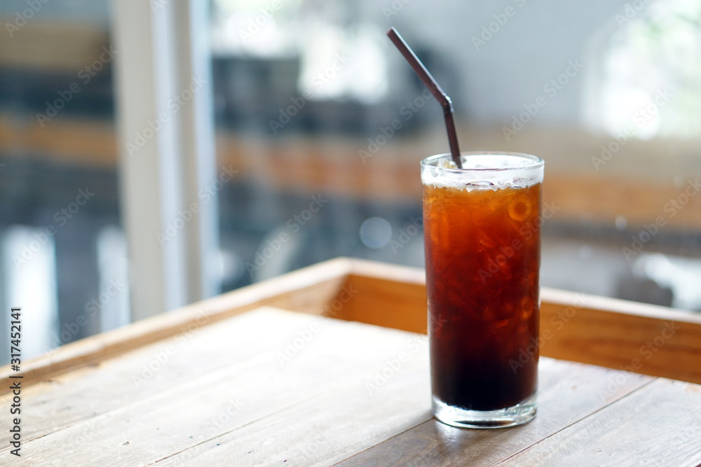 Iced americano - A glass of black coffee on table and copy space, The style of coffee prepared by brewing espresso and mixed with water, Refreshing summer drink concept. Iced americano - A glass of black coffee on table and copy space, The style of coffee prepared by brewing espresso and mixed with water, Refreshing summer drink concept.