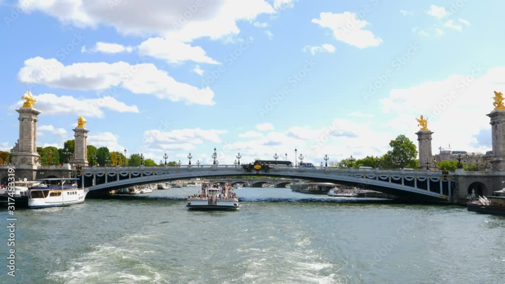 Tourist boat sails under the Alexander III bridge on a sunny day in Paris, France. Tourist boat sails under the Alexander III bridge on a sunny day in Paris, France.