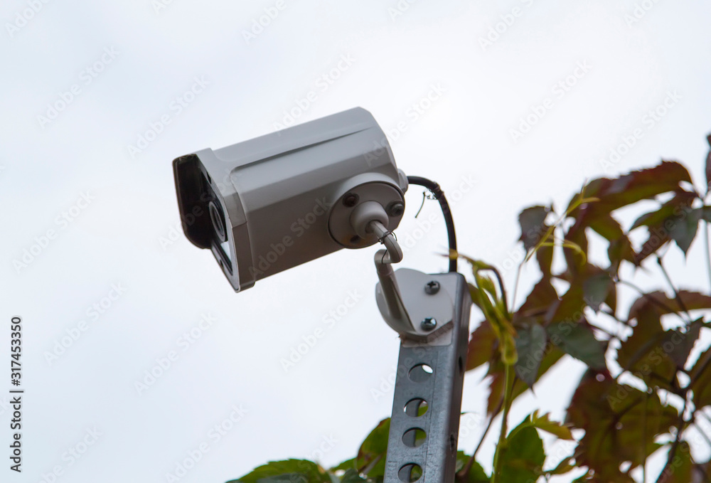 Surveillance and safety home concept. Security CCTV camera monitoring perimeter of private house in village