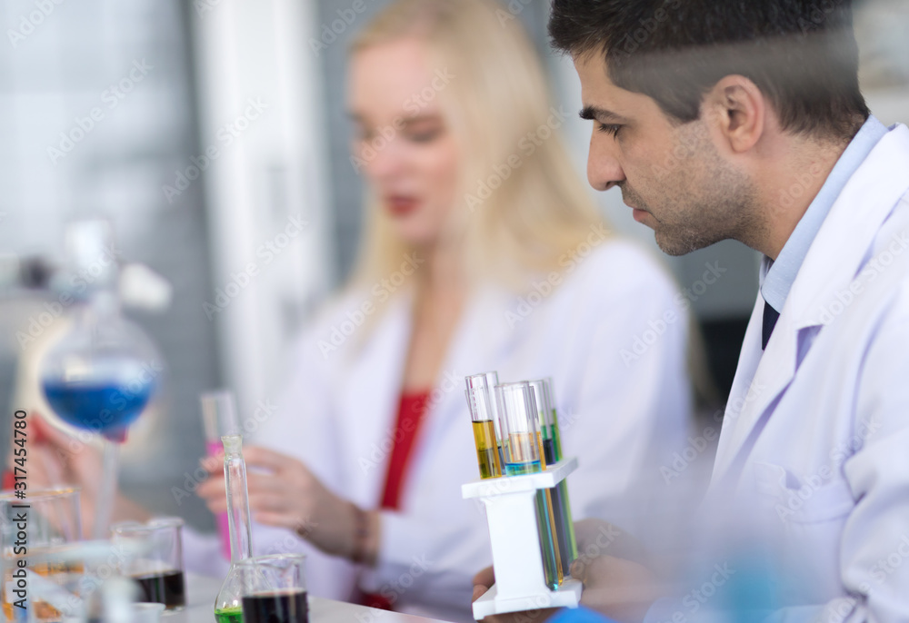 Male scientists and white female scientists are experimenting with chemicals in the laboratory. Male scientists and white female scientists are experimenting with chemicals in the laboratory.
