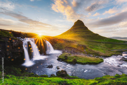 Morning landscape with rising sun on Kirkjufellsfoss waterfall and Kirkjufell mountain, Iceland, Europe. Landscape photography