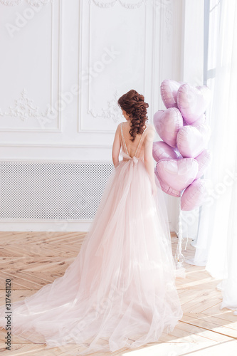 Beautiful woman holding pink balloons heart shaped. Model female on st. Valentine`s background. photo