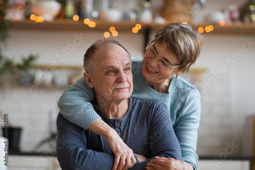 Portrait of relaxed fun senior couple together in their kitchen at home