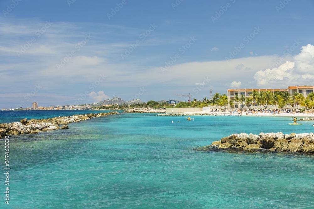 Amazing view of turquoise water of Atlantic ocean and blue sky with white clouds. Curacao island.. Beautiful nature background.