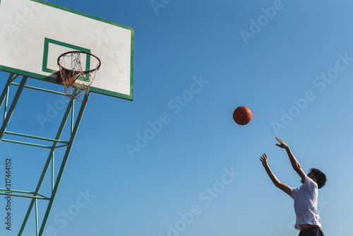 A male player throwing the ball into the basketball hoop