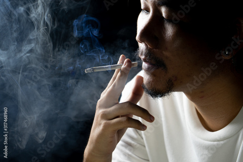 Asian men are smoking in a black background.