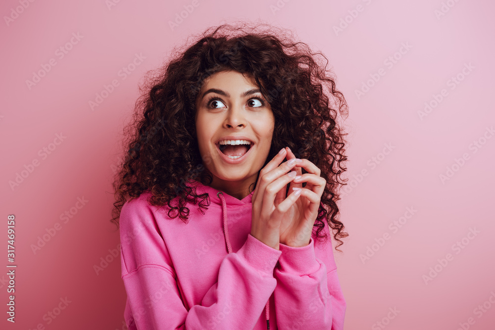 cunning bi-racial girl looking away while gesturing with joined fingers on pink background cunning bi-racial girl looking away while gesturing with joined fingers on pink background