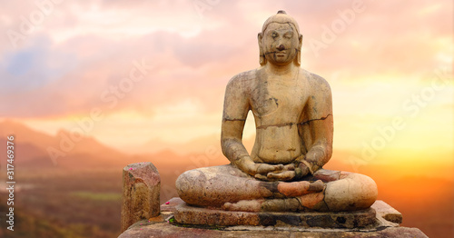 Ancient stone Buddha at sunset.