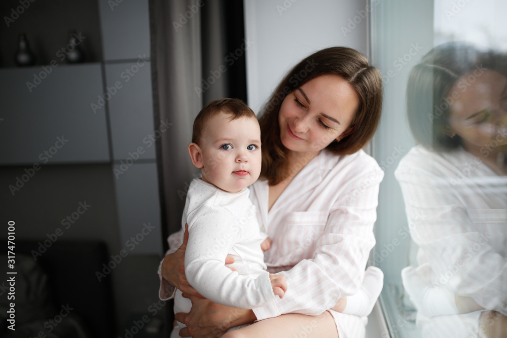 Tender mom and baby together near window lifestyle Tender mom and baby together near window lifestyle