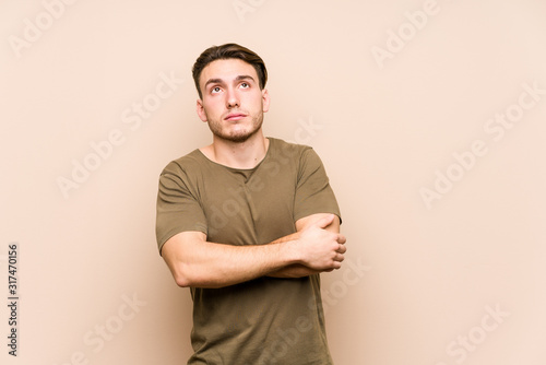 Young caucasian man posing isolated tired of a repetitive task.