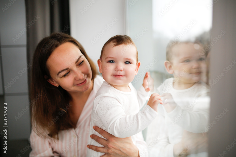 Tender mom and baby together near window lifestyle Tender mom and baby together near window lifestyle