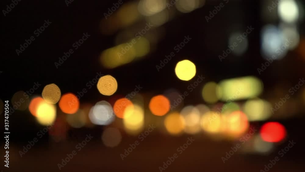 Defocused view of city traffic passing by on the street at night Defocused view of city traffic passing by on the street at night